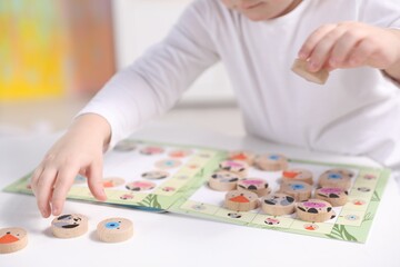 Cute little boy playing with toys at white table indoors, closeup