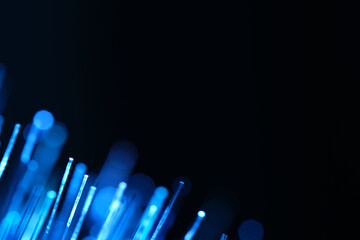 Abstract blue glowing fibers with soft bokeh on dark background. Digital connectivity and internet communication infrastructure concept. © freeman83