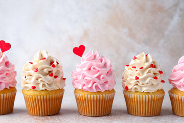 Happy Valentine's Day. Tasty cupcakes with red hearts on grey table, closeup