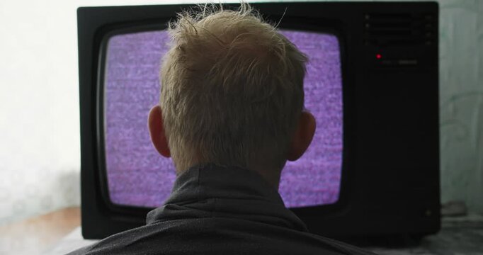 Human figure absorbed by static screen of old television set. Mindless viewing caused by analog media exposure