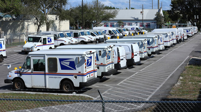 Fleet of United States Postal Service mail delivery vehicles parked at the USPS main facility in Oakland Park, Florida, USA. 