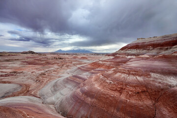 Colorful striped Bentonite hills under stormy sky in Utah desert