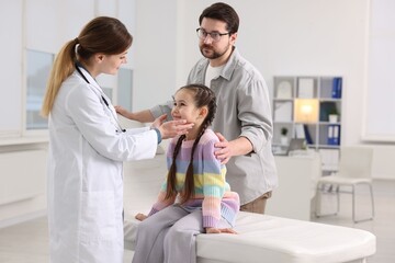 Obraz premium Little girl and her father having appointment with pediatrician in hospital. Doctor examining child