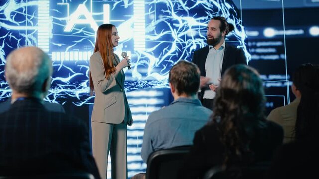 Two presenters hosting pitch presentation with AI features and data automation, software development with data science. Entrepreneur and speaker addresses investors and listeners. Camera B.