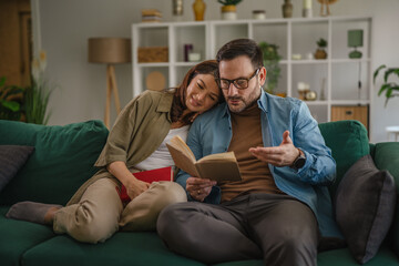 Obraz premium Loving couple relaxing at home reading books together