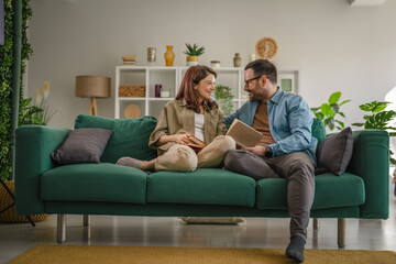 Obraz premium Couple relaxing together on sofa reading book
