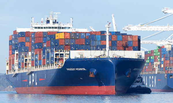 Oakland, CA - Feb 2, 2026: APL Cargo Ship President Monroe entering the port of Oakland with multiple tugboats assisting the vessel to maneuver.