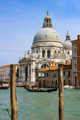 Naklejka premium Gondola on Grand Canal in Venice with Basilica Santa Maria della Salute and Historic Architecture on Sunny Day