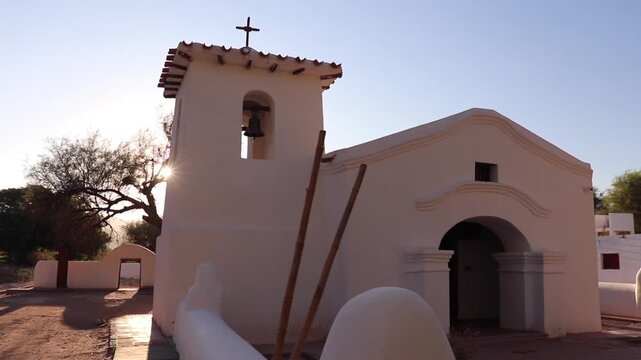 White adobe church surrounded by dry trees at sunset in Fiambala Catamarca Argentina.