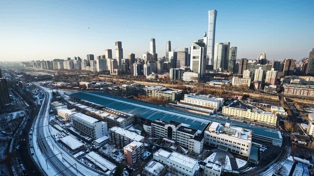 Snow-covered panoramic cityscape of Beijing&rsquo;s CBD, China, interwoven with urban railway tracks