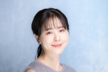 Fototapeta premium 水色背景で美容やスキンケアの明るいイメージのクローズアップカメラ目線