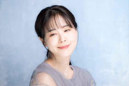 水色背景で美容やスキンケアの明るいイメージのクローズアップ　うつむく