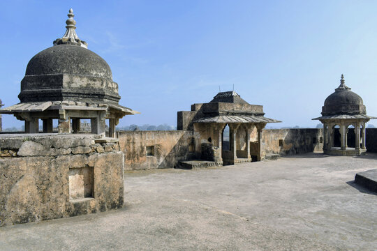 historic domed stone pavilions on an open terrace at rohtasgarh fort under clear blue sky