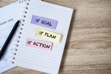 Notebook with showing goal, plan, and action text. Concept of business strategy, productivity, motivation and performance improvement.