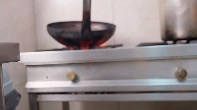 Professional chef heating wok on stove fire