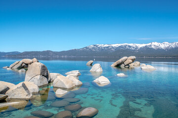 A beautiful lake with a rocky shoreline and mountains in the background