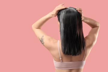 Obraz premium Young woman with graying hair on pink background, back view