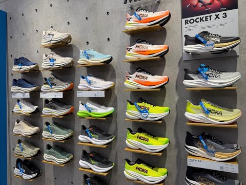 Rows of HOKA Running Shoes on Display Shelves in Retail Store.