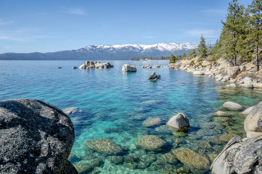 A beautiful lake with a rocky shoreline and mountains in the background
