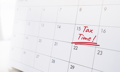 Close-up calendar page with handwritten red text Tax Time marked on a specific date. Annual tax season concept