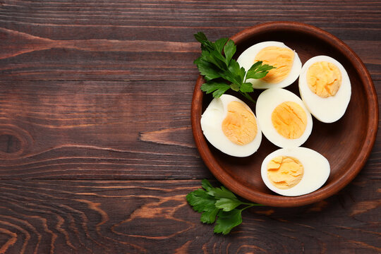 Plate with boiled eggs on wooden background, closeup