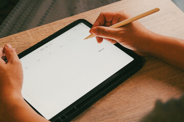 Businessman using stylus pen planning schedule on digital calendar tablet, concept of time management and business organization.