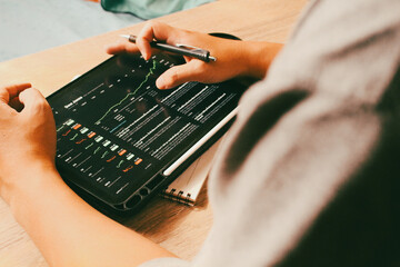 Businessman using pen to analyze stock market trading chart on digital tablet, concept of investment decision and financial strategy.
