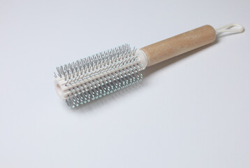 Fototapeta premium Round Hairbrush with Wooden Handle and Metallic Barrel..A professional round hairbrush featuring a cylindrical metallic barrel with evenly spaced bristles and a smooth wooden handle. 