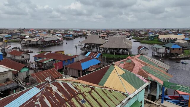 A close-up aerial perspective looking down at the diverse, weathered rooftops of wooden stilt houses in the water-based community of Ganvie Floating Village in Benin West Africa