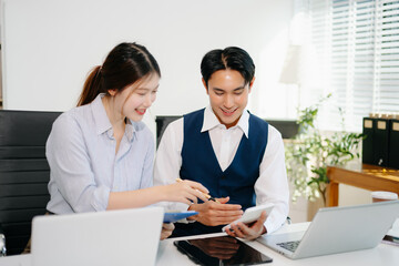 Obraz premium Business coworkers working together at office desk using laptop. Professional teamwork, corporate collaboration, digital strategy, productivity