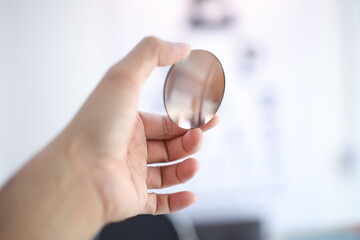 Hand a doctor holding sunglasses leans, brown lense glasses in hand 