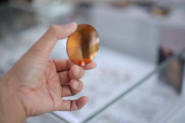 Hand a doctor holding orange sunglasses leans, lense glasses in hand 