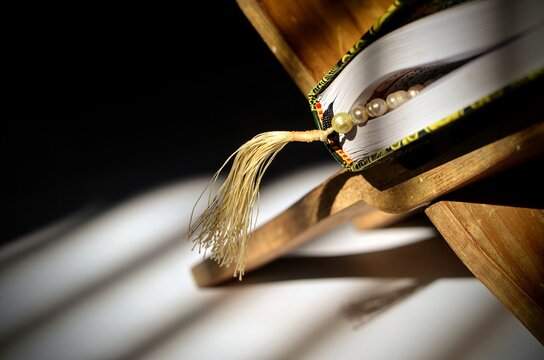Macro of prayer beads tassel on Quran and rehal symbol of islam ramadan eid