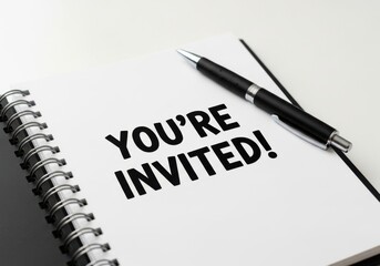 Invitation to a party with a notebook and pen on a table