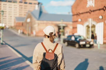 Obraz premium Woman tourist Visiting in Hakodate, happy Traveler sightseeing Kanemori Red Brick Warehouse in spring season. landmark and popular for attractions in Hokkaido, Japan. Travel and Vacation concept