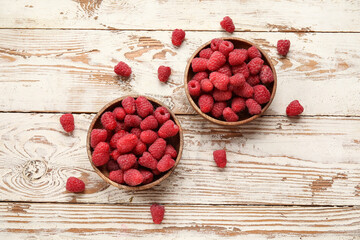 Naklejka premium Bowls with fresh raspberry on light wooden background