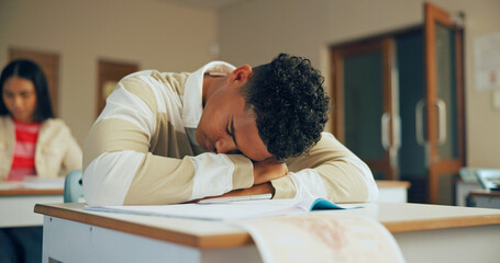 Sleeping, education and student in classroom with test, exam or assignment with fatigue or burnout. Tired, learning and boy teenager in lesson with exhaustion for studying with quiz at school. © MagicDavid25/peopleimages.com