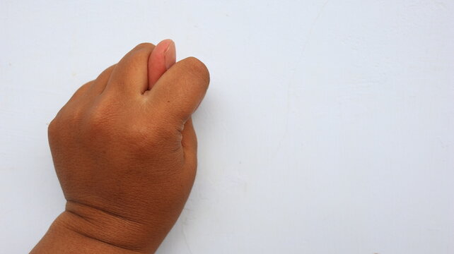 Human hand making figa gesture on white background symbolizing luck or rejection