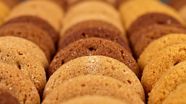 Rows of delicious cookies showcase varying shades of brown and texture. A sweet assortment of baked treats creates an inviting pattern.