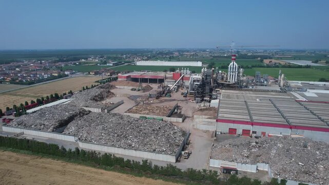 drone view of an integrated cement manufacturing plant showing rotary kiln line, preheater tower, clinker cooling system, raw material storage yards and heavy industrial processing infrastructure.