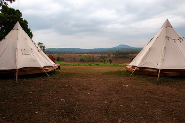 Camping in the forest with a white teepee tent. © Pongsorn