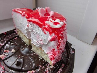 Slice of strawberry cake with white cream and red glaze. Sweet dessert for unhealthy food concept, rich sugar content.