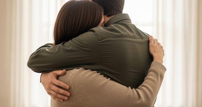 Couple embrace affectionately near window natural light