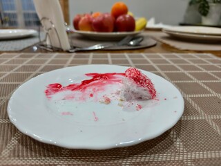 Leftover piece of unhealthy cake on a white plate after party or dinner. Concept of diet fail, indulgence, or finished celebration.