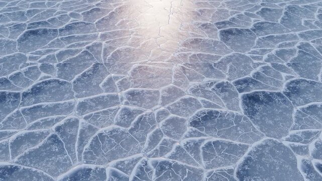 Cinematic aerial view of frozen lake surface with thick cracked ice patterns at sunset during winter