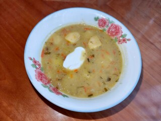 Lentil soup with sour cream served in a floral bowl. Creamy vegetarian meal for lunch or dinner. Healthy food concept.