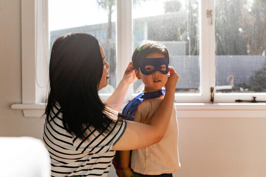 Asian mum help young son put on his mask