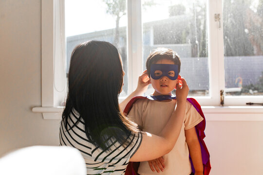 Asian mum help young son put on his mask