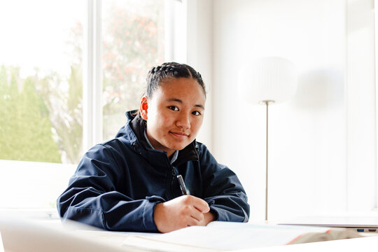 Teenage Samoan girl doing her homework on the table