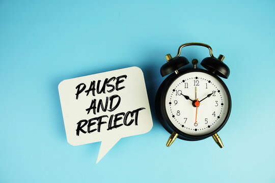 Pause And Reflect text on speech bubble with alarm clock on blue background